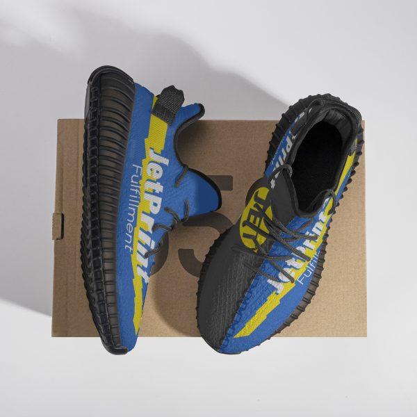 A pair of blue and black road running shoes are placed on a paper shoe box