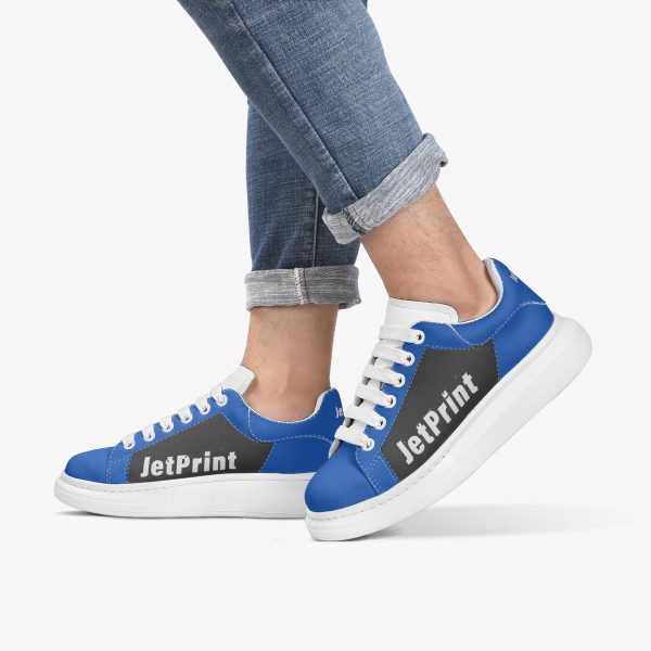 A model wears a pair of blue and black oversized sneakers with a logo