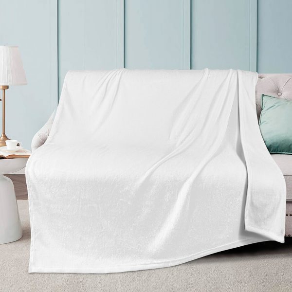 Pure white wool blanket is opened and placed on the sofa