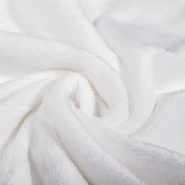 Part of a pure white fleece blanket is rolled up