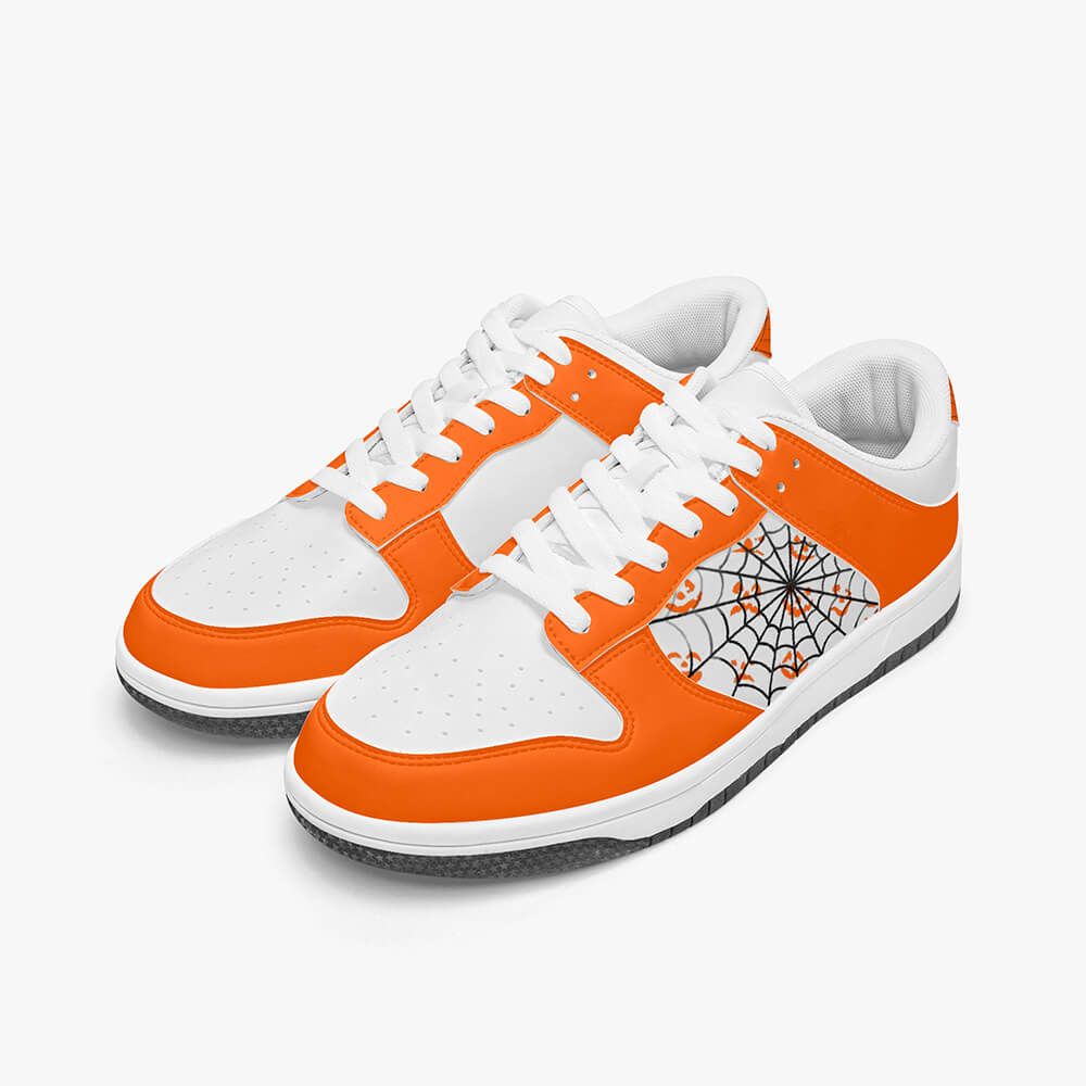 A pair of orange low-top sneakers with a Halloween spider web