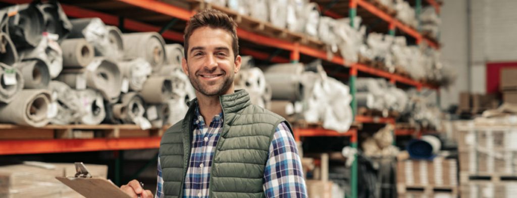 A man is inspecting products in a carpet company