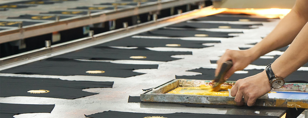 A worker is screen printing