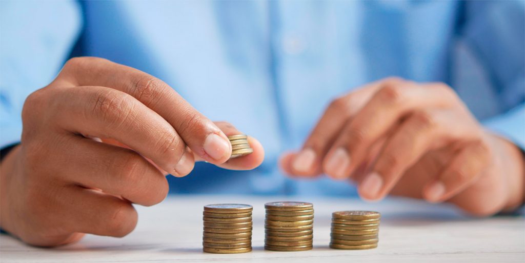 A man is stacking gold coins with his hands