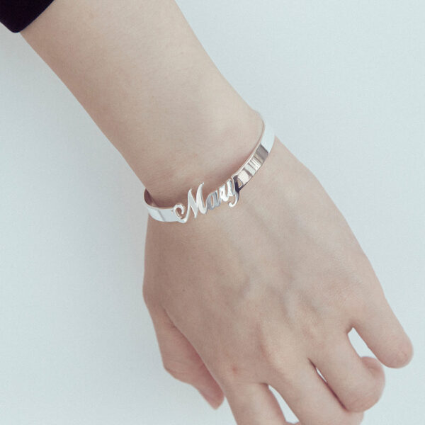 A female model wears a silver open bracelet