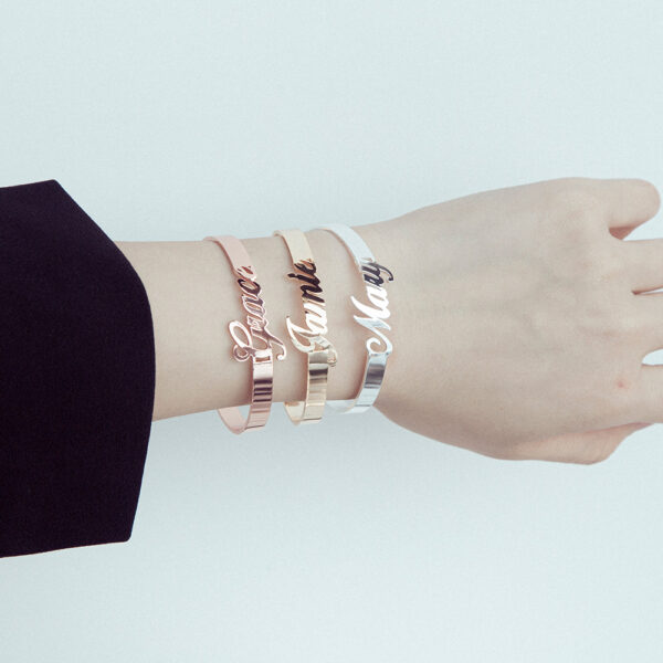 A female model wears three open bracelets in different colors