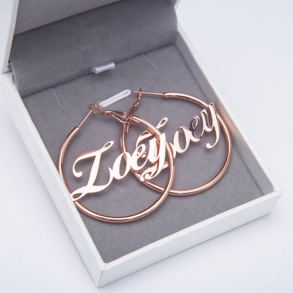 A pair of rose gold hoop earrings are housed in a jewelry box