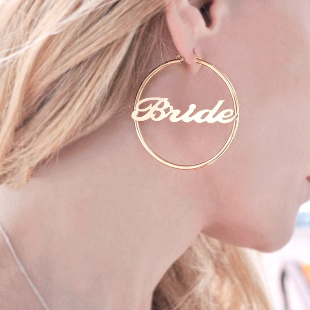 A female model wearing a gold customizable earring