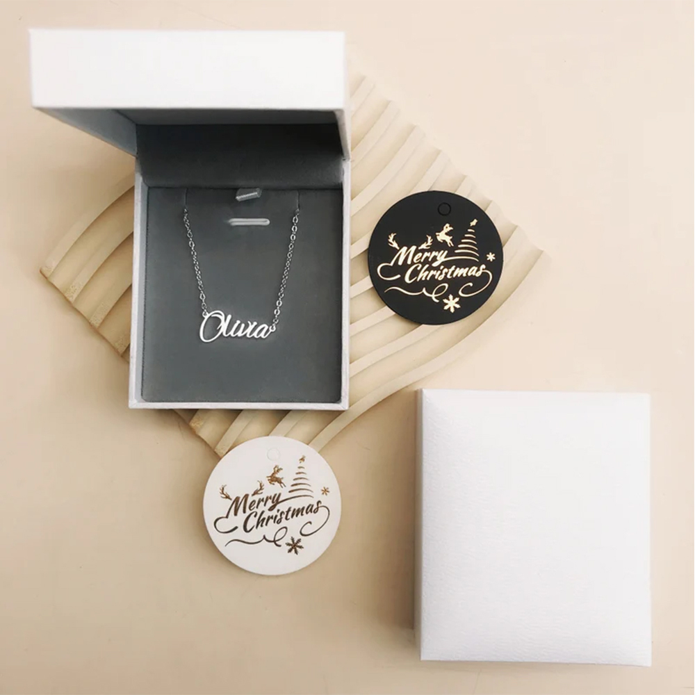 A gold customizable necklace is placed in a gift box