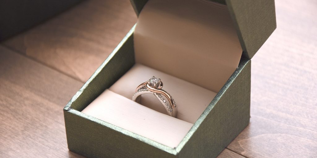 A diamond ring is placed in a ring box