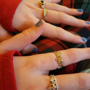 A woman wearing many custom gold rings