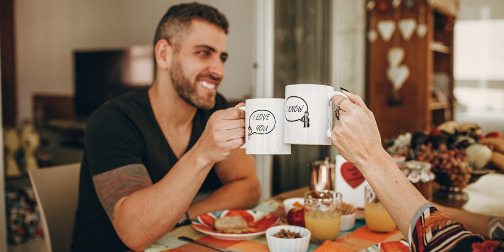 Two people are celebrating with mugs