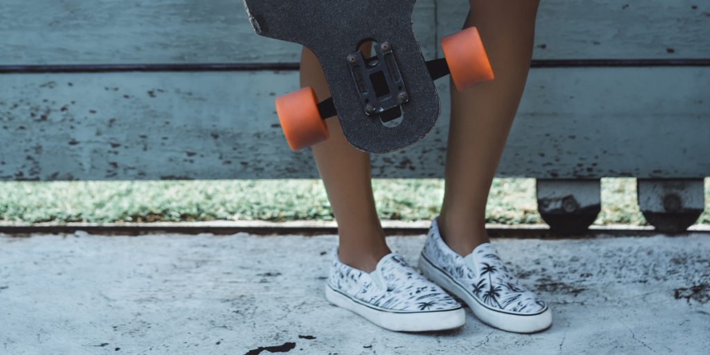 A skater boy wearing a pair of white canvas shoes