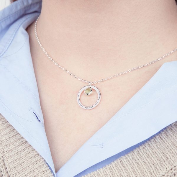 A female model wears a silver ring band birthstone necklace