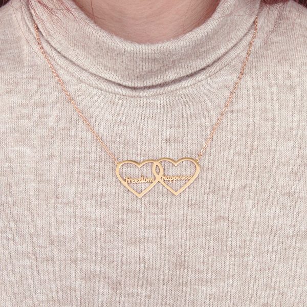 A female model wears a golden double heart necklace