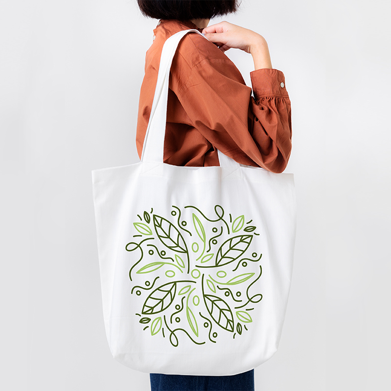 A female model is carrying a bag with a green design pattern