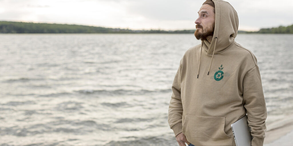 A man wearing a brown hoodie with an eco-friendly graphic