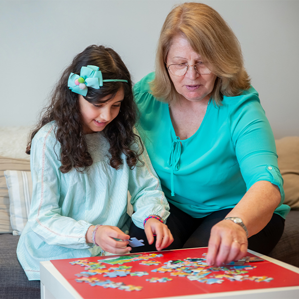 Grandma with granddaughter doing puzzle