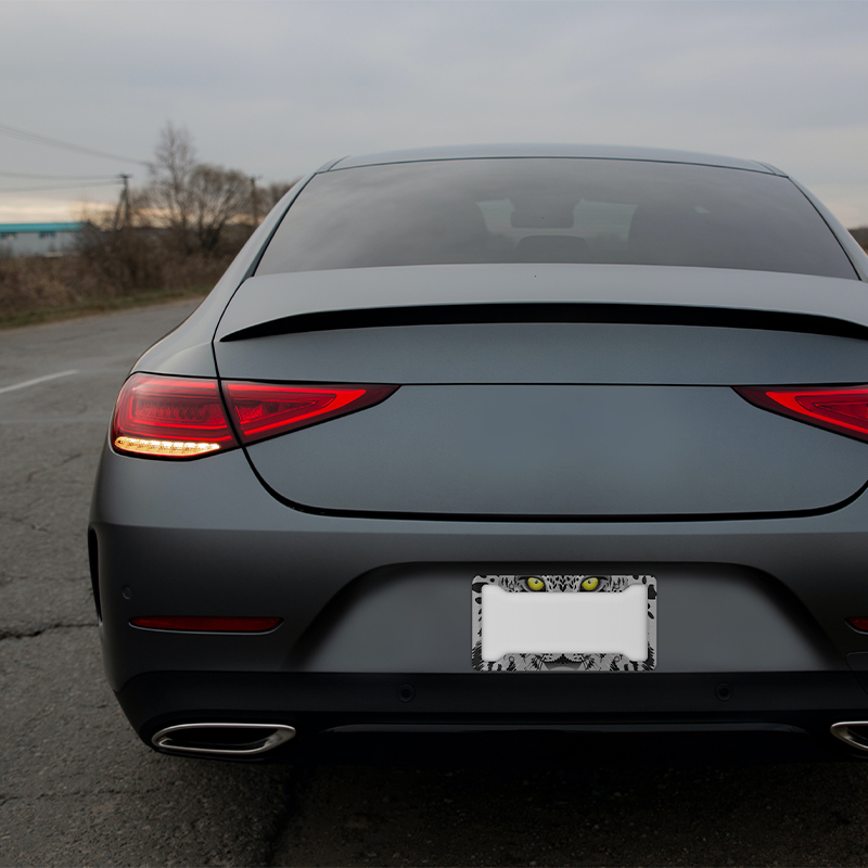 A gray car with a custom license plate frame