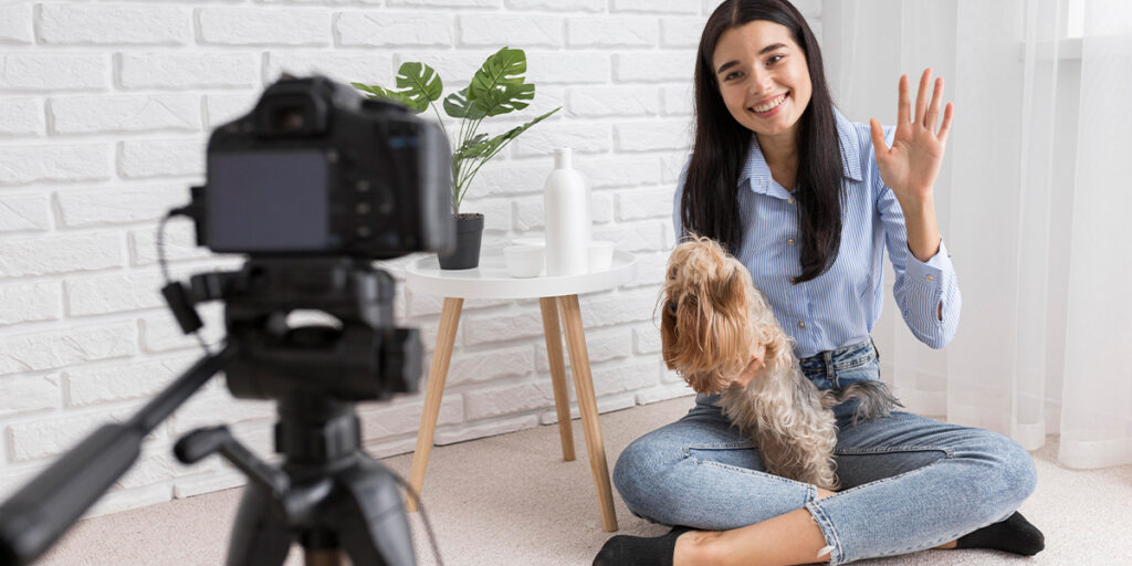 A woman taking a photo with her pet dog