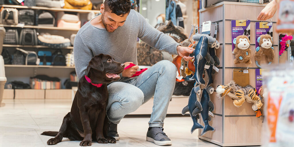 A man with his pet dog is picking out pet supplies