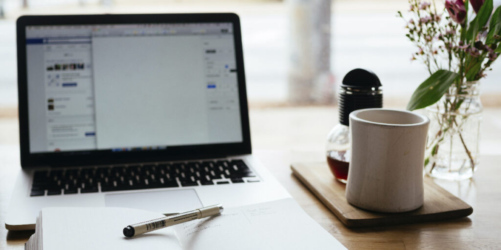 A notebook is placed in front of a computer