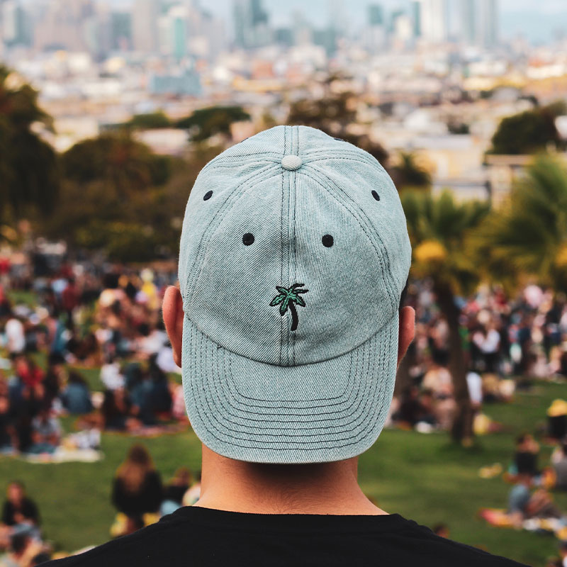 A man wears a light blue embroidered baseball cap