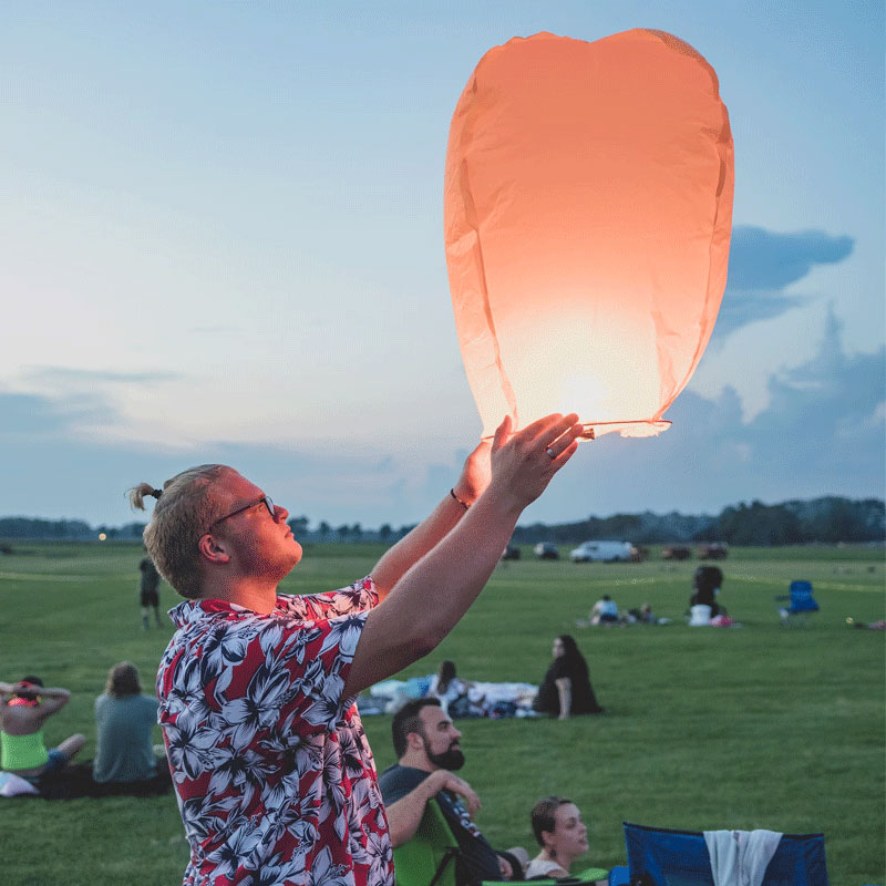 A man wearing a Hawaiian shirt is playing Sky lantern