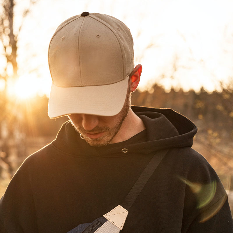 A man wears a brown baseball cap