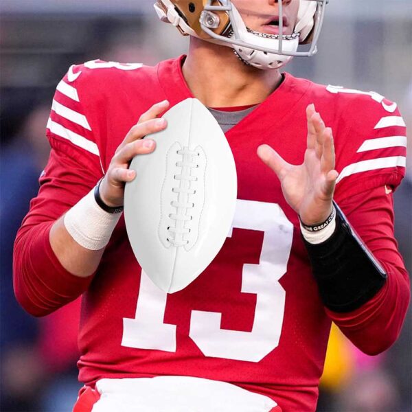 A football player holds a customizable American football