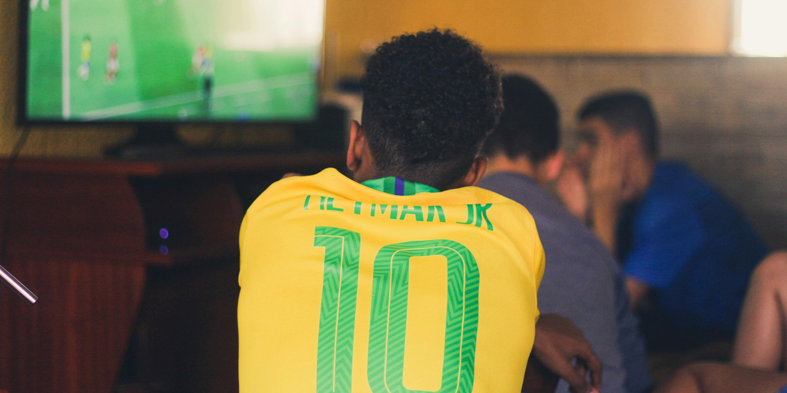 A man wearing a soccer jersey is watching a soccer match