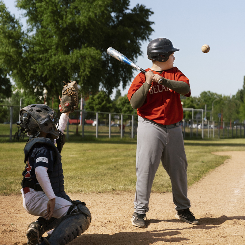 Two teenage baseball players are playing baseball