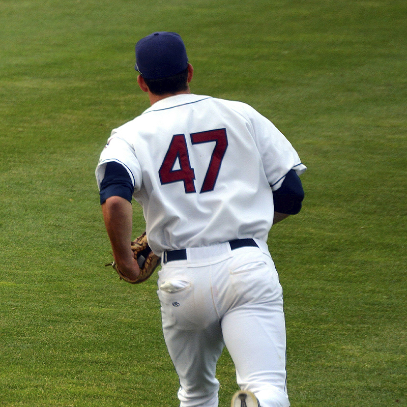 Adult baseball player wearing white baseball jersey