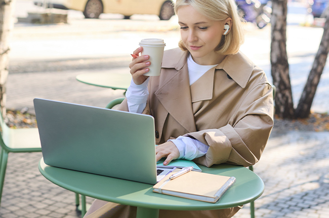 A female freelancer is drinking coffee in front of the computer