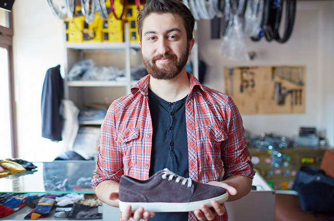 A male POD seller is displaying the shoes he sells