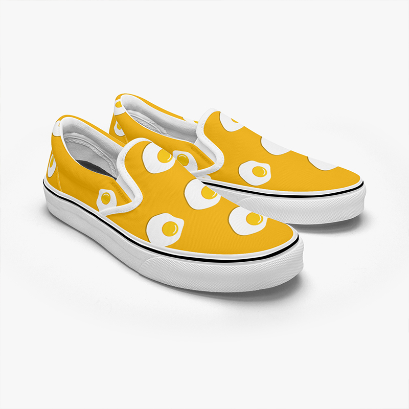 A pair of yellow canvas shoes with a fried egg pattern