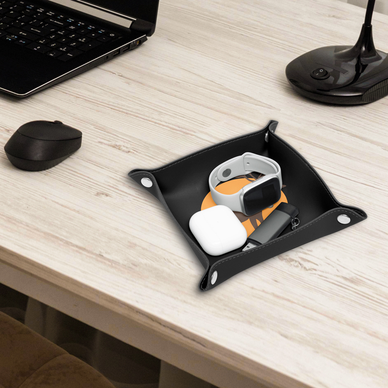 A black leather valet tray is placed on the computer desk