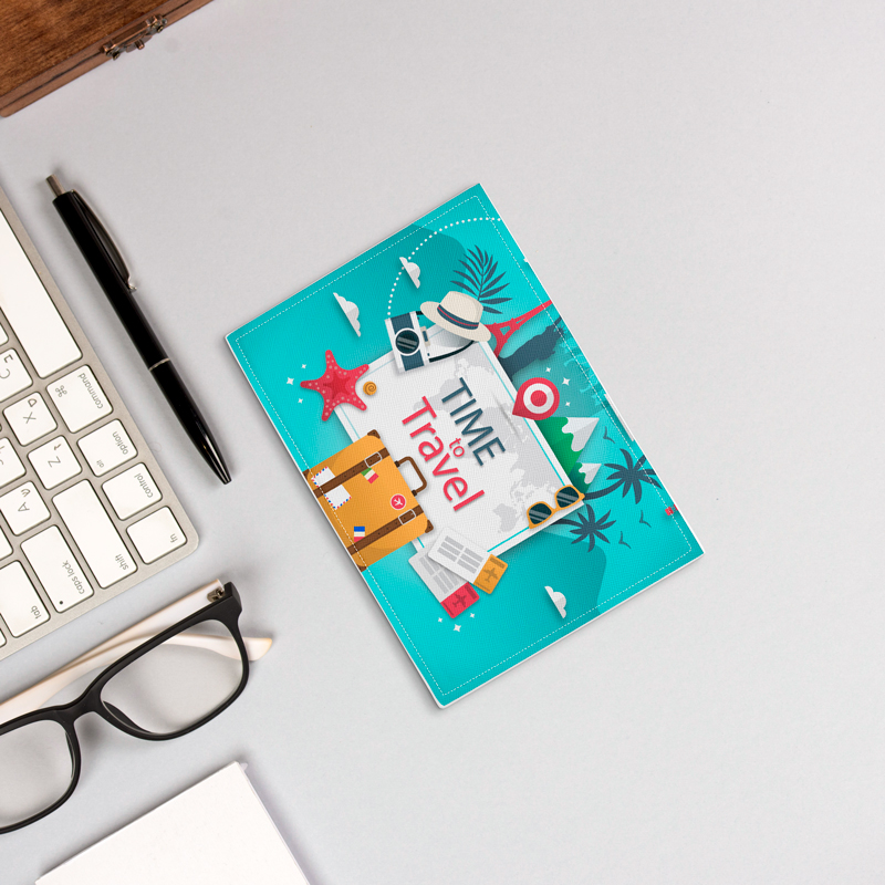 A cyan passport cover with travel illustration is placed on the table