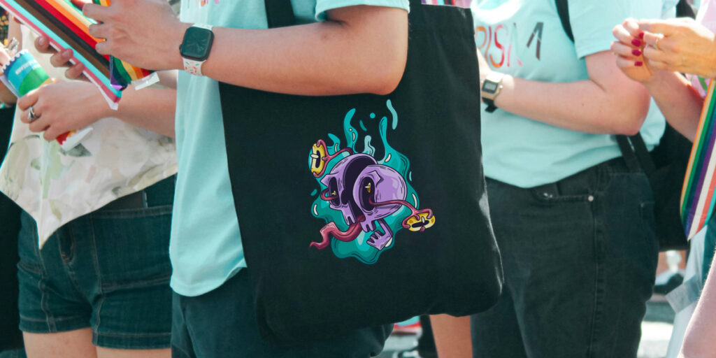 A woman carries a black tote bag with a graffiti design