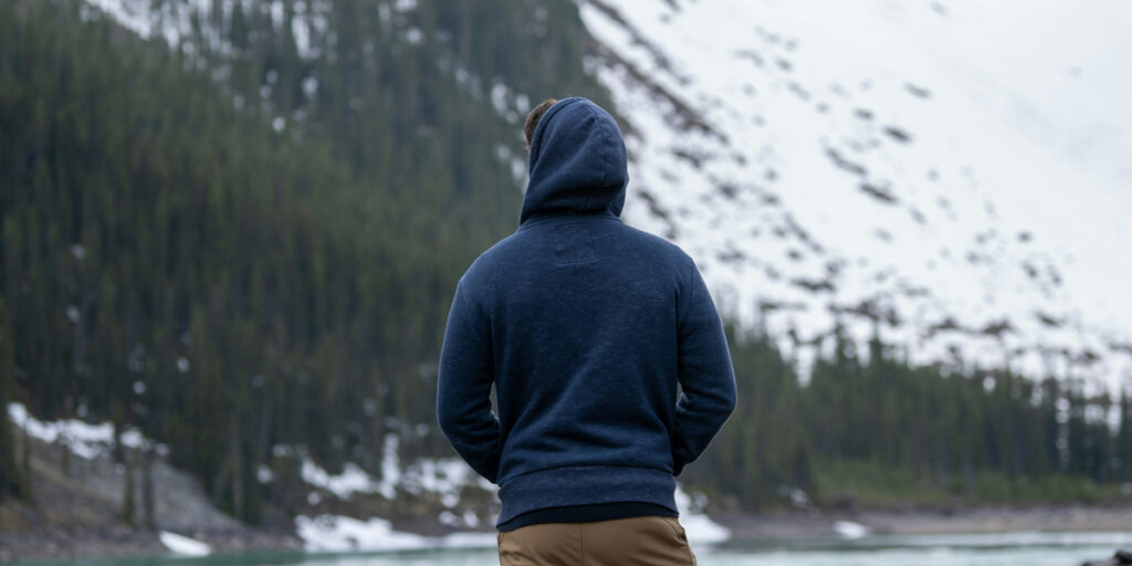 A man wearing a dark hoodie looking at the scenery