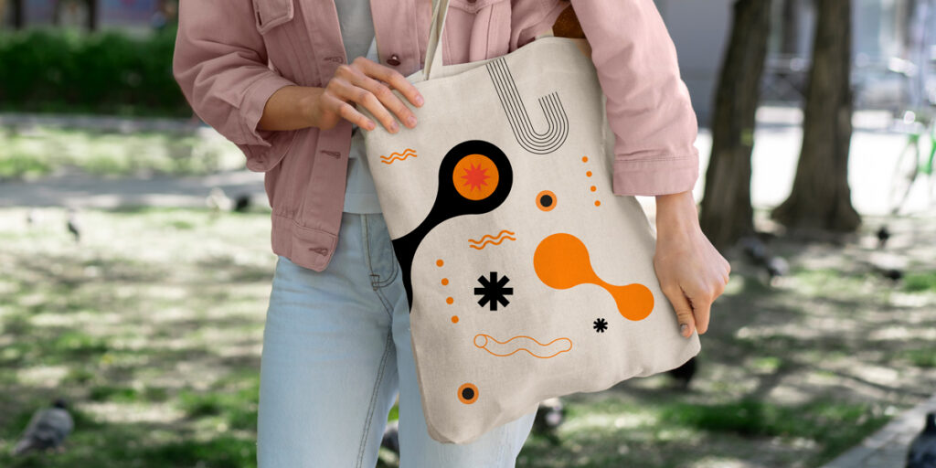 A woman holds a tote bag with an abstract pattern