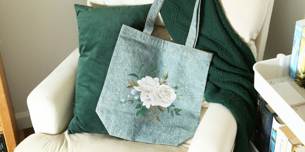 a tote bag with a floral design is hung on a stool