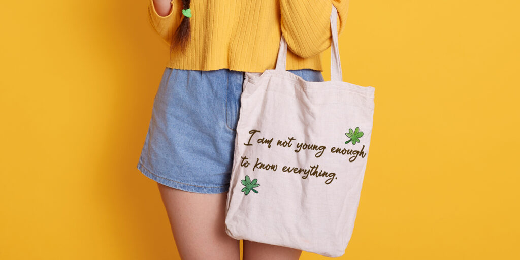 A woman holds a tote bag with a funny pun