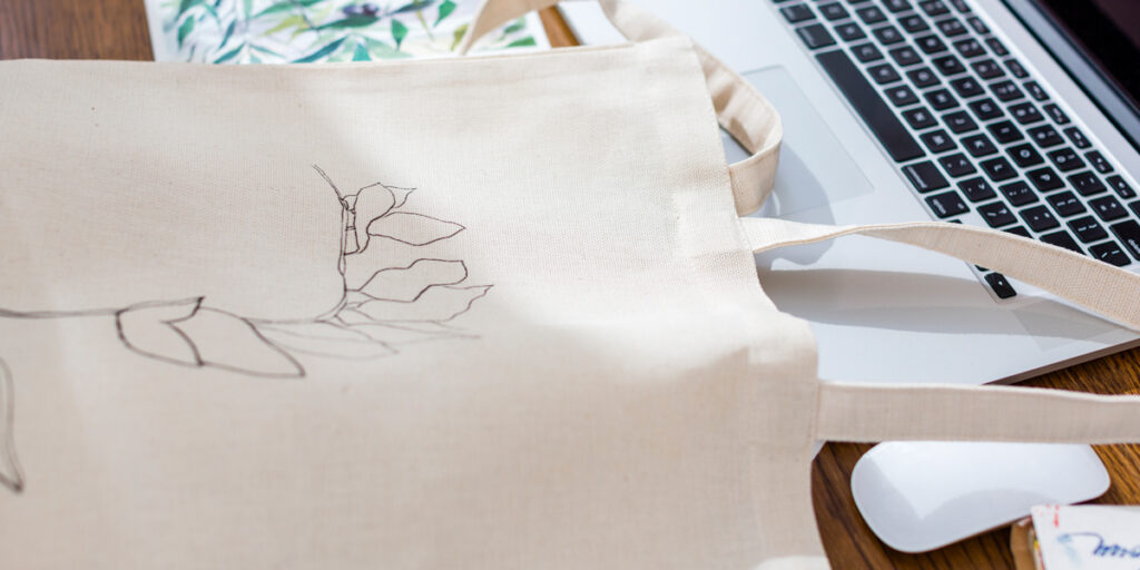 A tote bag with a line design is placed on the table