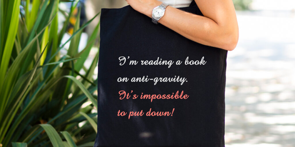 A woman holds a tote bag with a famous quote