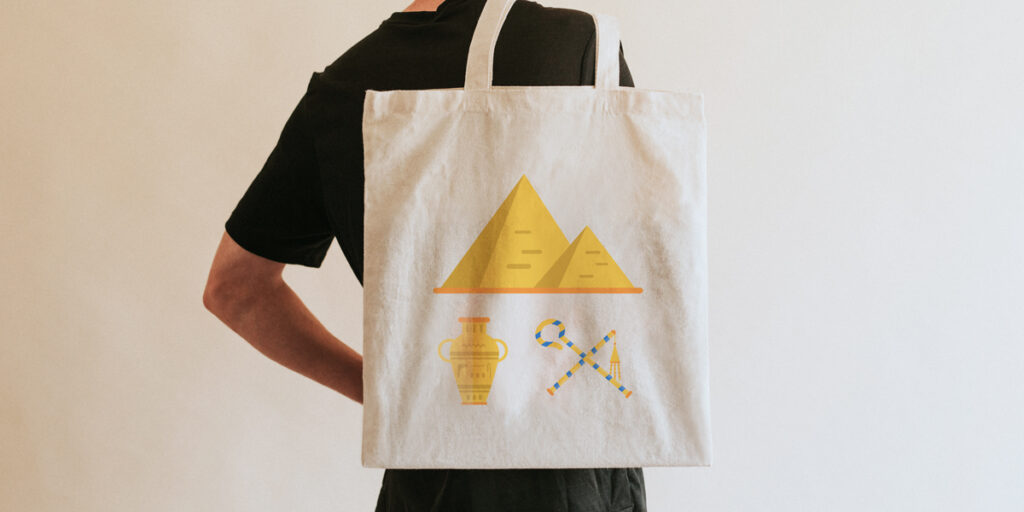 A man carries a tote bag with a pyramid on it