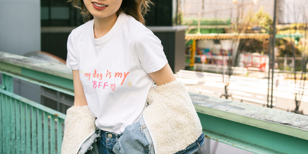 A woman wearing a white T-shirt with a pet saying printed on it