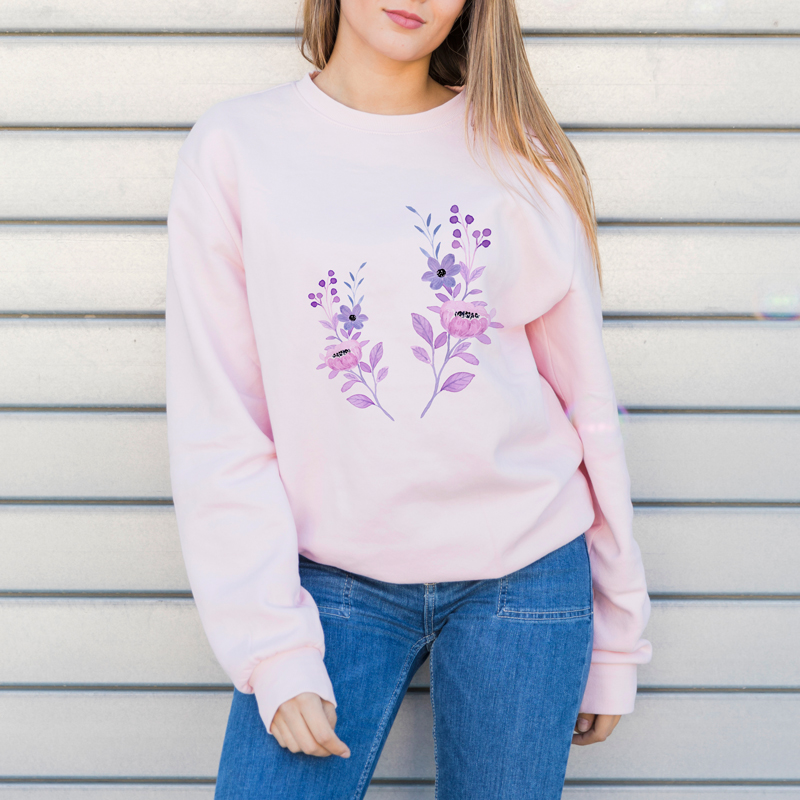 A woman wearing a pink sweatshirt with a floral pattern