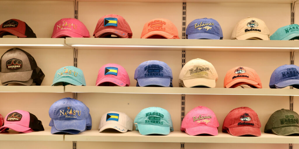Many hats are displayed on wooden racks